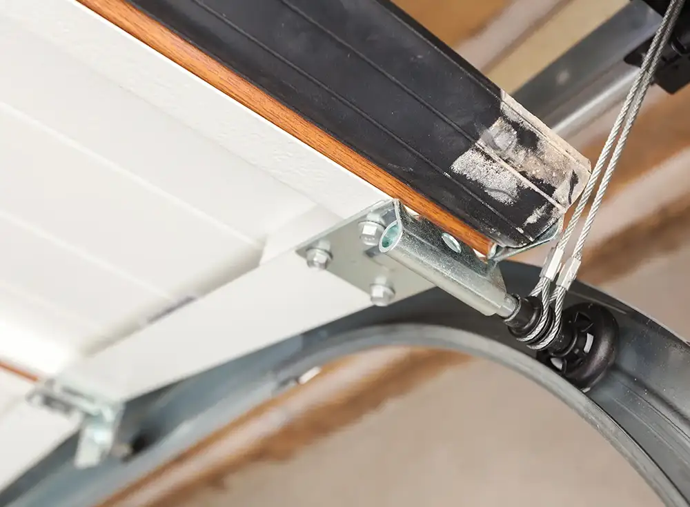 aligned garage door track with cables attached to roller.