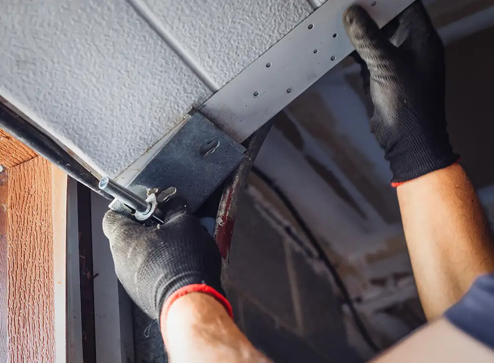 garage door technician performing maintenance on garage door's track alignment in Springfield IL
